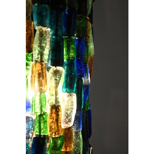 Colorful vintage pendant. The base is made of brass and the light shines beautiful through the colorful glass beads. In a...
