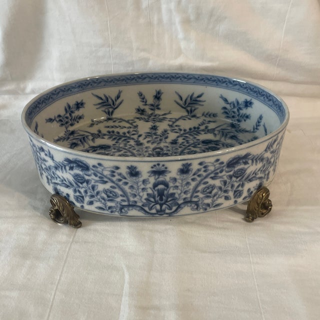 Stunning blue and white footed planter catchall bowl. Handcrafted of porcelain and brass. About Winward Home: Beauty can...
