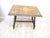 This table with top inlaid with various woods and bone, has ebonized finished turned legs and is 19.75"H x 24"L x 16"D.