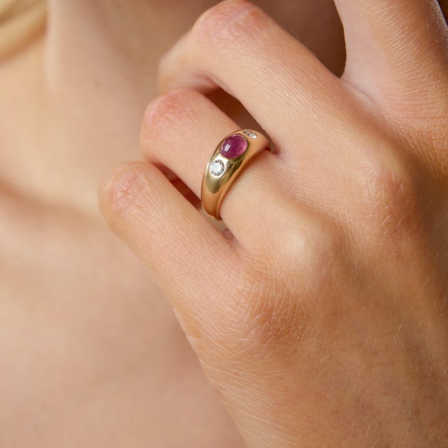 A bold and refined vintage statement from the 1980s, this striking ring centers on a richly saturated cabochon ruby, its...