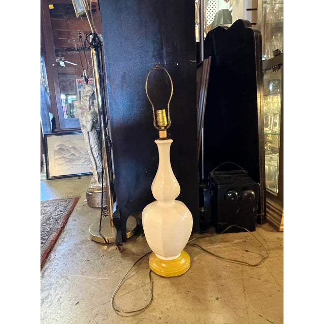 The is cream color double gourd ceramic body in a cream color. The body has about 8” diameter. Base is painted metal in...