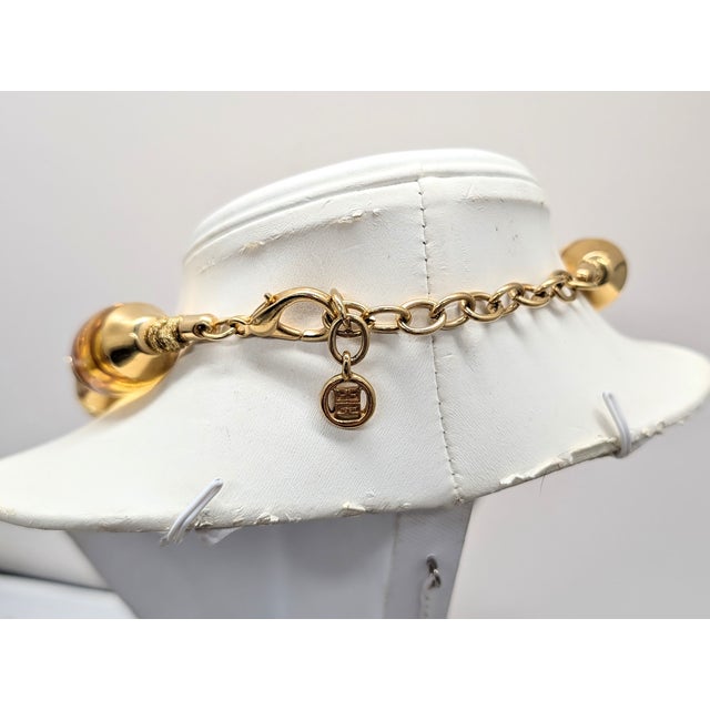 1980s goldtone with goldtone thred holding together ovoid amber resin beads with bubbles in them with smooth caps on...