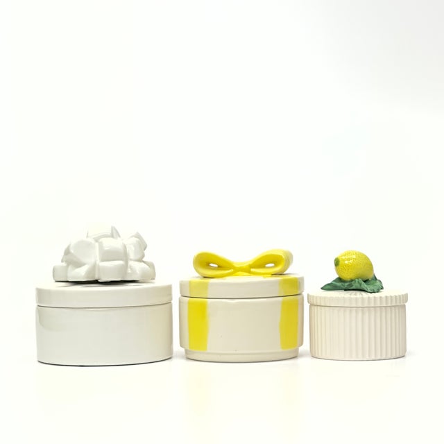 Yellow and white-lidded containers, group of 3. Mixed set of yellow and white ceramic "gift box" lidded containers storage...