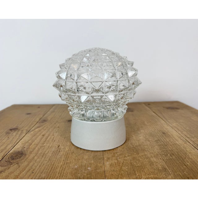 Vintage industrial ceiling or wall light made in former Czechoslivakia during the 1970s. It features a white porcelain...