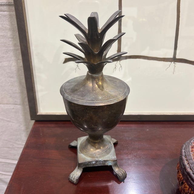 vintage Hollywood Regency style solid brass pineapple urn, often featuring a removable lid with detailed leaf top and...