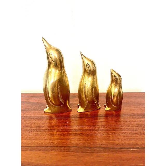 A charming trio of brass penguins, dating from the 1960s–1970s, composed of three silhouettes of varying sizes. with their...