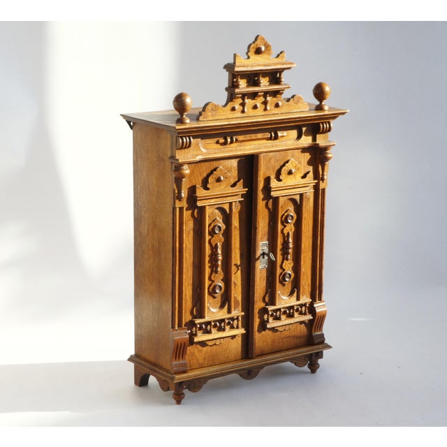 Antique solid oak small cabinet in Gothic style with so many hand carved ornaments all over. It has two doors and in the...