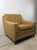 This mid century modern lounge chair features original yellow upholstery and small tapered legs with brass capped feet.