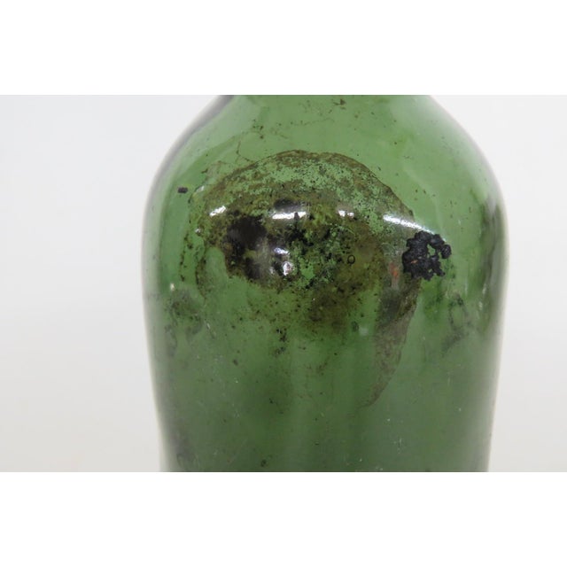 This lovely Empty Bottle is made out of mold-blown glass. This gorgeous bottle presents a rich olive green color to the...
