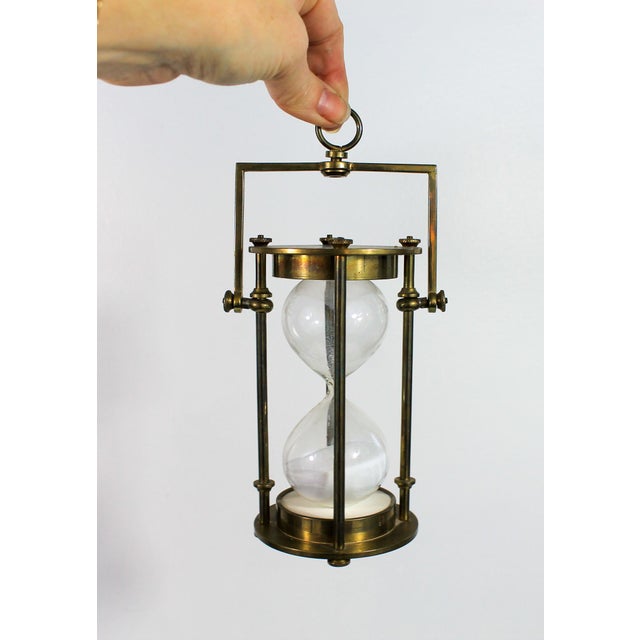 Vintage hangable brass hourglass or egg timer. No makers mark. Patina on brass. Measures, 7.5"H when hanging.