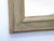 This weathered wood mirror has traces of gray-green and gold paint and measures 47.5"H x 42"W.