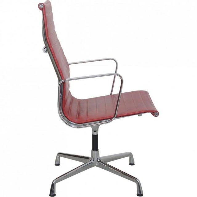 Charles Eames Ea-109 office chair upholstered in red leather, and with a chrome frame and armrests. The chair is from 2007...