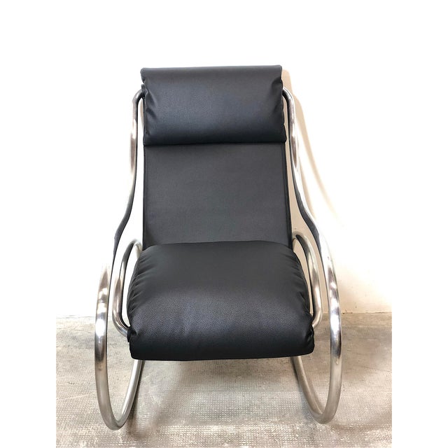 Rocking chair made by Heals, London, 1970s. The chair features a tubular steel frame and black eco-leather, completely...