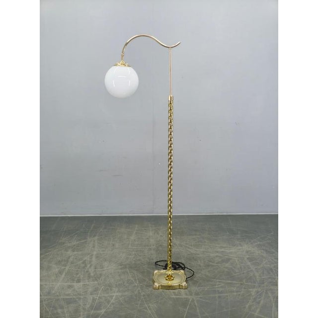 Exceptional Italian Art Deco floor lamp from the 1930s featuring a sculptural twisted brass column, elegant curved arm,...