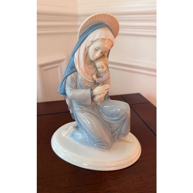 Beautiful vintage German porcelain figurine depicting the Madonna tenderly holding the Christ Child. Rendered in a serene...
