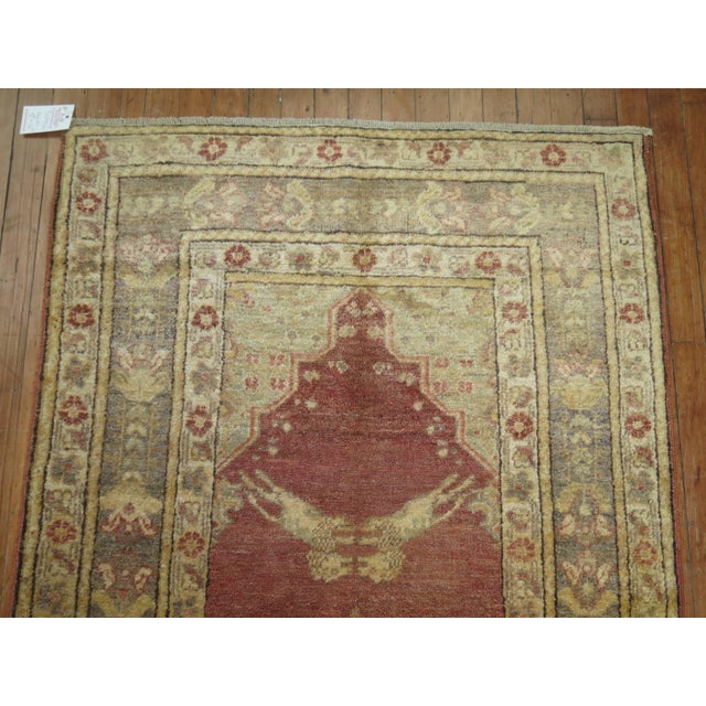 A decorative subtle colored Turkish runner depicting four lions in between a central medallion motif and multiple borders....