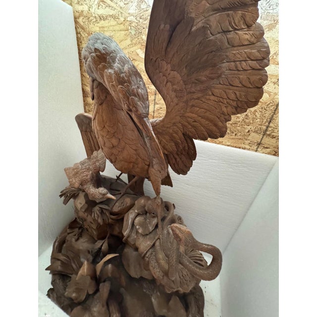 Monumental hand-carved solid wood sculpture depicting an elaborate marshland wildlife scene featuring a large wading bird...