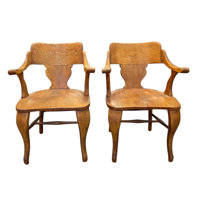 This Pair of English Arts & Crafts Solid Quarter-Sawn Oak Armchairs, Early 20th Century is uniquely elegant and contoured...