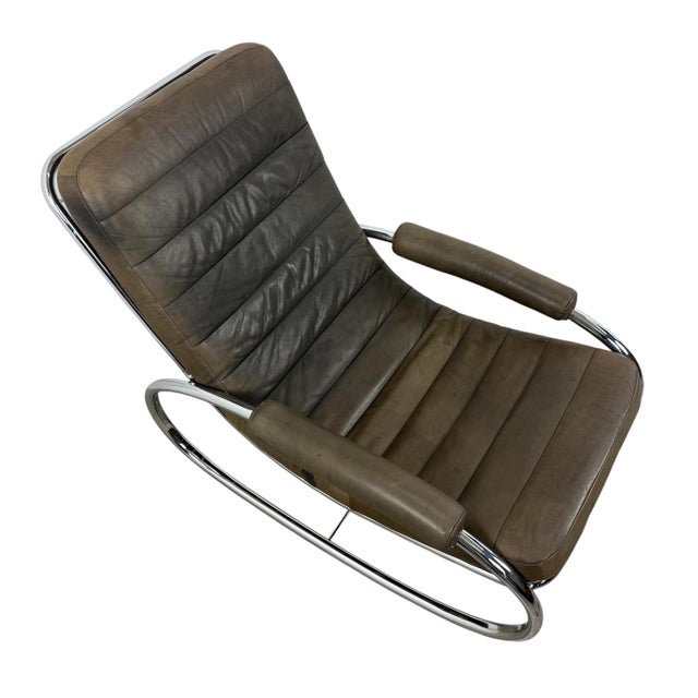 A striking vintage Bauhaus-inspired rocking chair featuring a graceful tubular chrome steel frame and generously...
