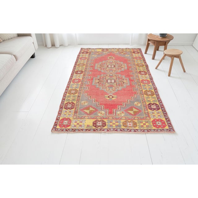 This is a vintage Turkish Oushak rug from the Mid 20th Century. The piece was hand-knotted.