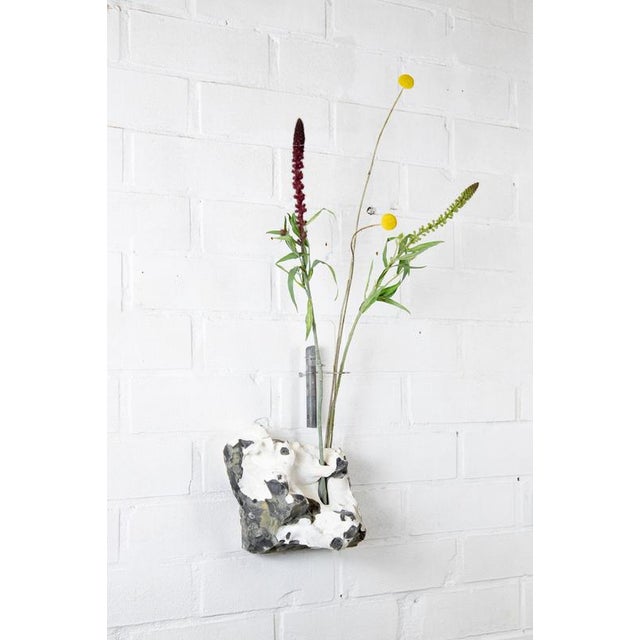 Flintstone silex curved wall mounted flower vessel by studio do dimensions: d 28,5 x w 13 x h 20 cm materials: stainless...