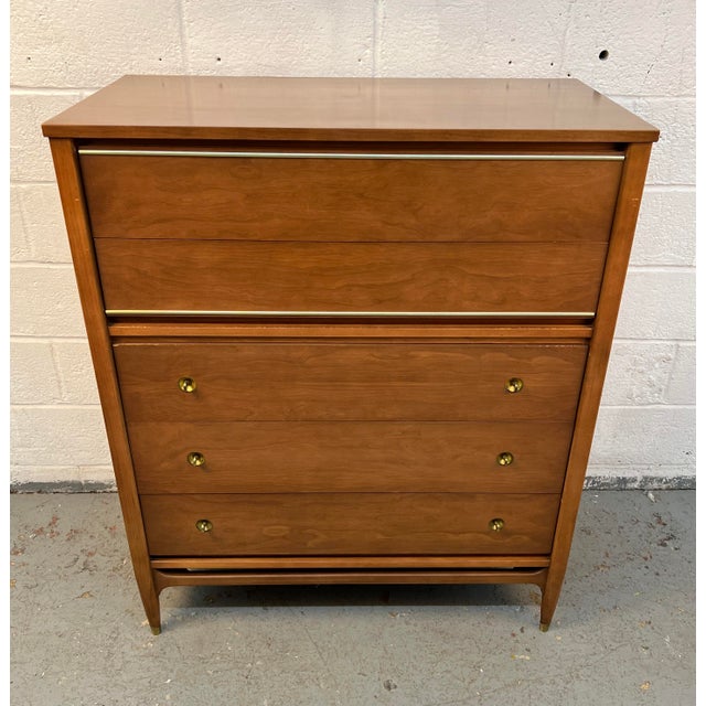 A striking example of Mid-Century Modern design, this Mainline by Hooker highboy dresser combines sleek functionality with...
