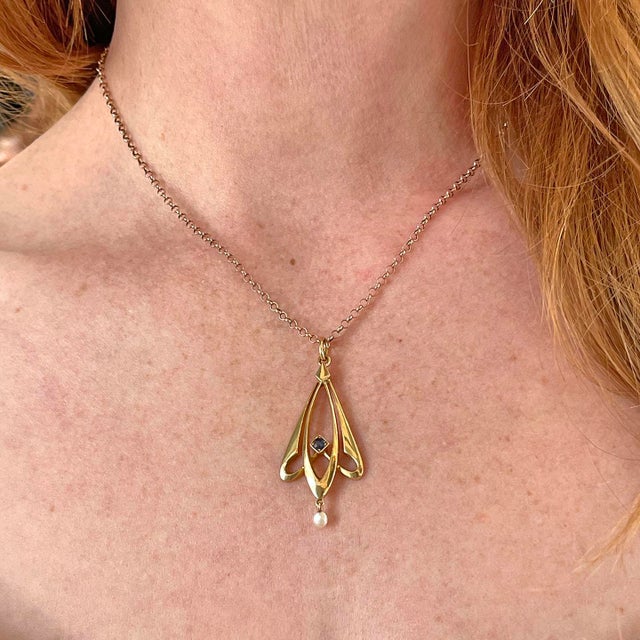 A whisper of golden elegance, as if plucked from the pages of love story. This pendant, a study in graceful curves and...