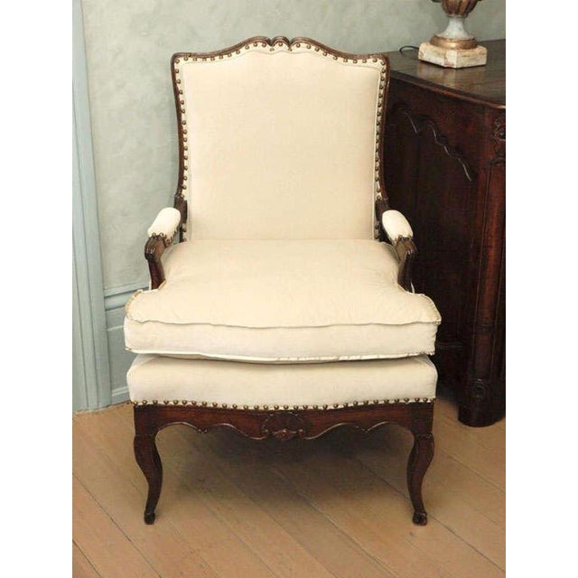 Beautifully carved 18th C Regence Walnut Arm chair with all new upholstery. Ivory Cotton Velvet detailed with satin flat...