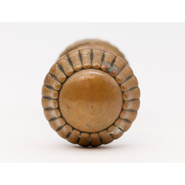 Radial fluted bronze entry door knobs with an antique patina. The manufacturer and date of creation is unknown. Sold as...