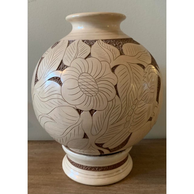 Unique hand-carved vase with separate base in tan and brown tones. Beautiful carved design includes flowers, vines, leaves...