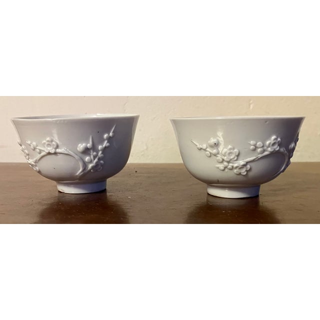 Pair antique 19th century Chinese export blanc de Chine porcelain tea cups or bowls decorated with relief molded flowering...