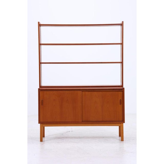 A beautiful vintage teak bookcase from the 1960s with a clean, upright design and a calm, even grain. It appears light in...