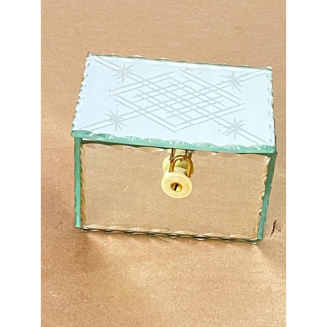 It is a rectangular beveled glass box. It is closed by a padlock, which is rather decorative. This box was made in France...