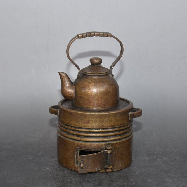 Well-crafted vintage solid bronze warming set combining a lifting-handle teapot and matching charcoal stove. The...
