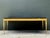 A vintage cocktail table crafted with a striking combination of a black stone top and a gilt brass base. The rectangular...