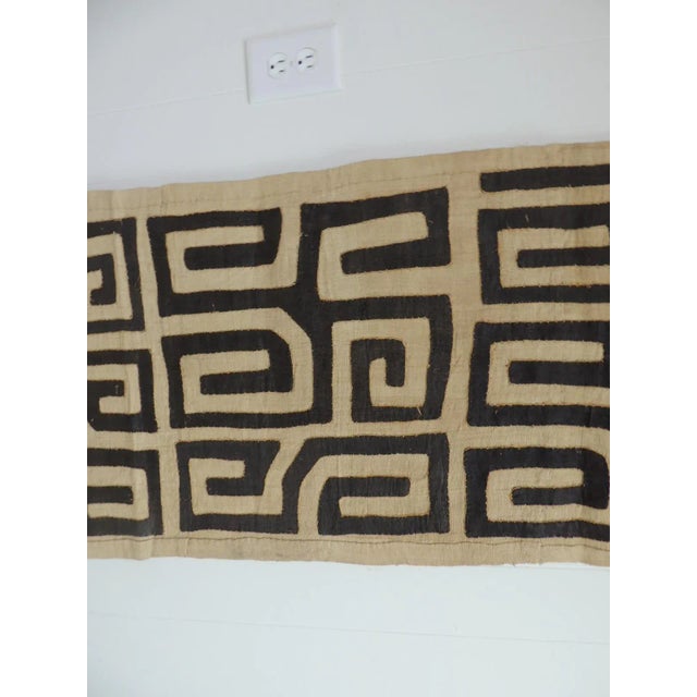 Vintage natural and black African applique Kuba textile with orange raphia stitches. Size: 20" W x 95" L.