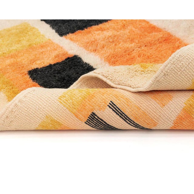 Bold architectural silhouettes rising from an ivory ground, like a skyline glimpsed at night. This hand-knotted wool rug...