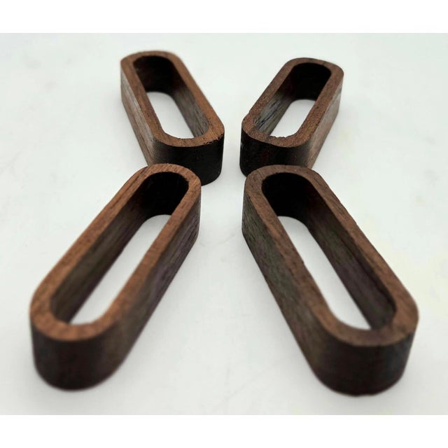 Offered is a set of 4 mid 20th Century Teak wood napkin rings made in Denmark in the 1960s. They each measure: 2.5" W x 1"...