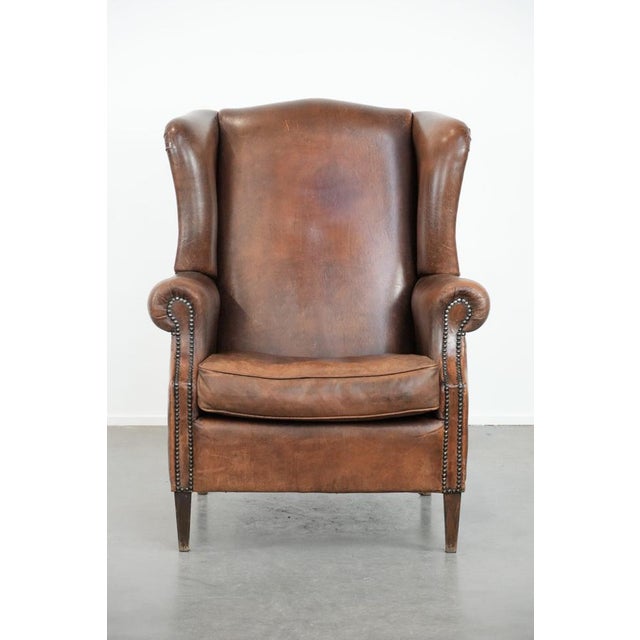 We are offering this charming, large vintage wingback chair made of sheepskin, featuring beautiful colors and a...