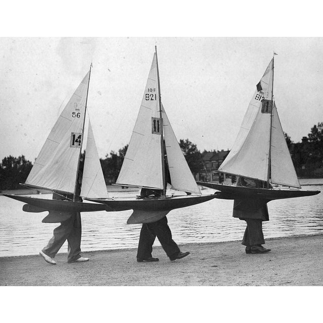 Model Boats 20th June 1937: Three competitors for the 'Scrutton' Medals carrying their model sailing boats to the starting...