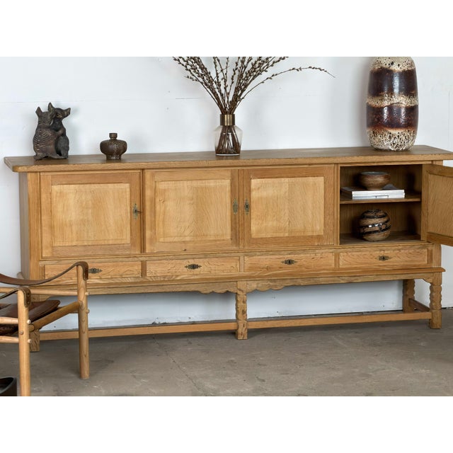 Large low sideboard in oak by Henning Kjærnulf, made in Denmark during the 1960s. Its unusually long horizontal case...