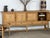 Large low sideboard in oak by Henning Kjærnulf, made in Denmark during the 1960s. Its unusually long horizontal case...