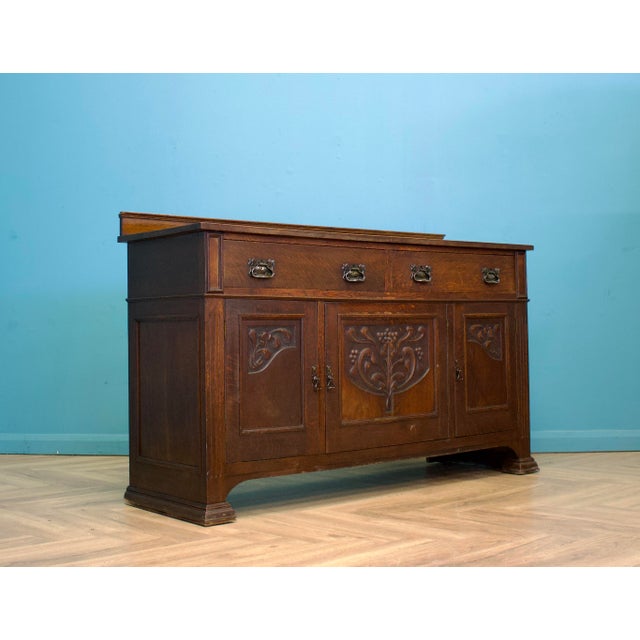 Early 20th century oak sideboard with carved Art Nouveau panels and original brass handles throughout. The design combines...