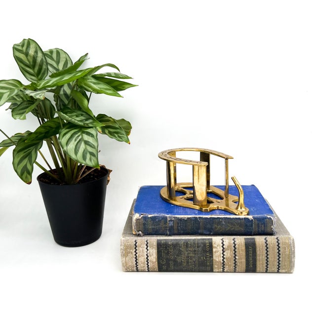 Inviting brass wall-mounted hat holder from circa the 1970's featuring a classic horseshoe form with engraved geometric...