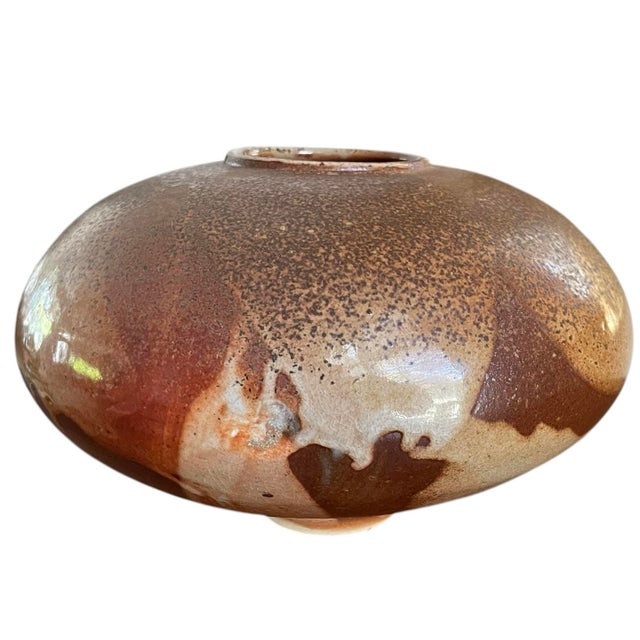 Hand-thrown boho studio pottery vessel with a wide, low-profile silhouette and beautifully layered earth-tone glazes. Warm...