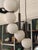 Cascade-style pendant lamp featuring 12 white opal glass spheres and a black metal frame. Made in Italy. The design...