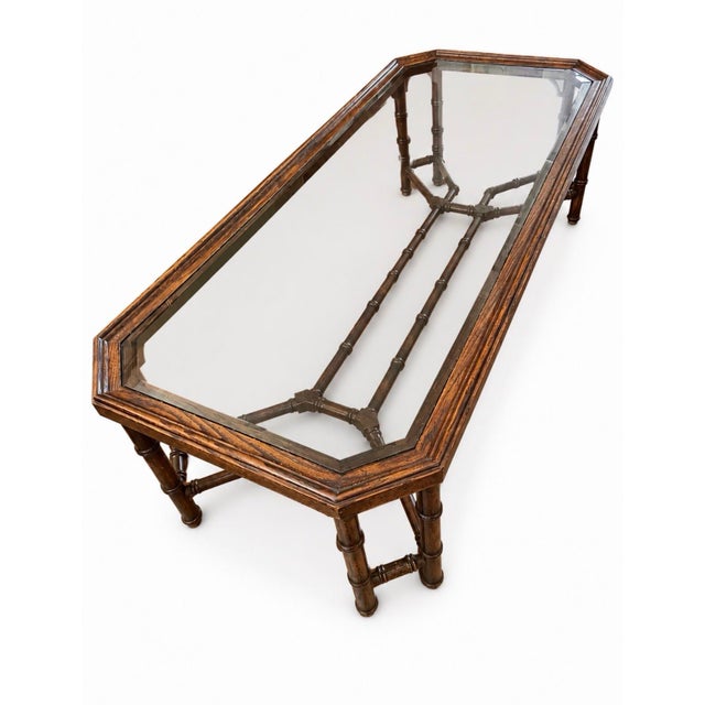 This vintage coffee table is likely a 1970s Chinese Chippendale style piece featuring a faux bamboo wooden base and a...