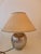 Vintage table lamp in a classic-decorative style with a glazed ceramic base with a silver finish, likely achieved with a...