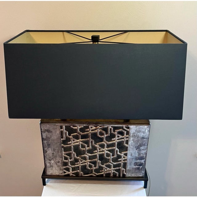 Add a touch of modern elegance to your home with this Baker table lamp. The lamp features a sleek silver finish and an...