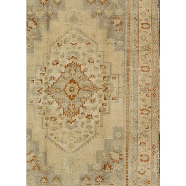 Measures: 6'10'' x 11'3''. This Oushak carpet (circa mid-20th century) features a multi-layered medallion framed in the...